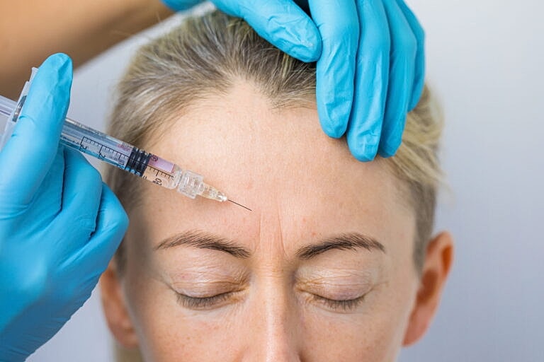 Botox injection procedure on a woman's forehead.