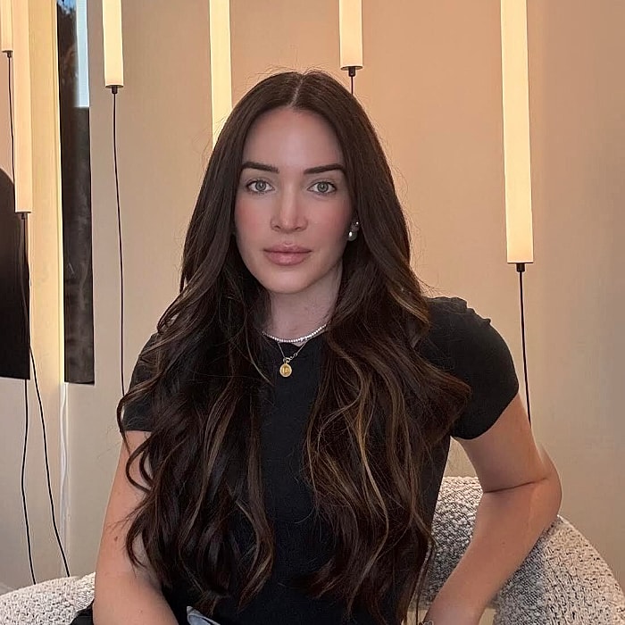 Woman with long hair posing indoors.
