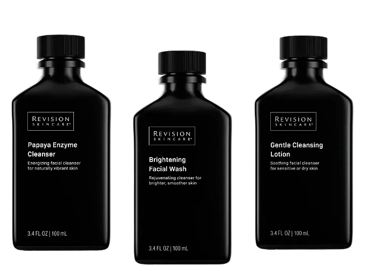 Revision Skincare facial cleansers in black bottles.