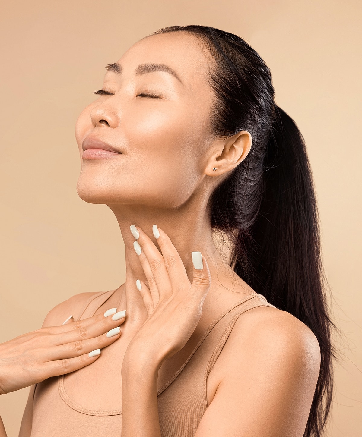 Woman with closed eyes, hands on neck gracefully.