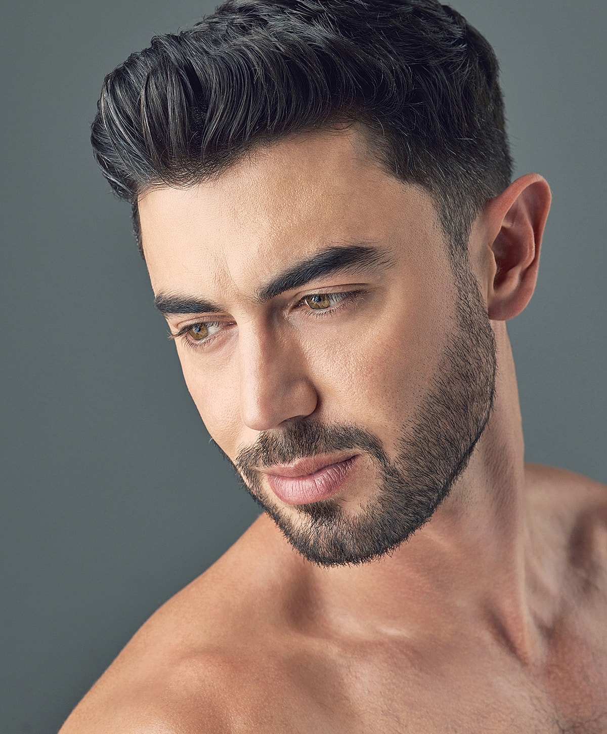 Close-up of man with beard and styled hair.