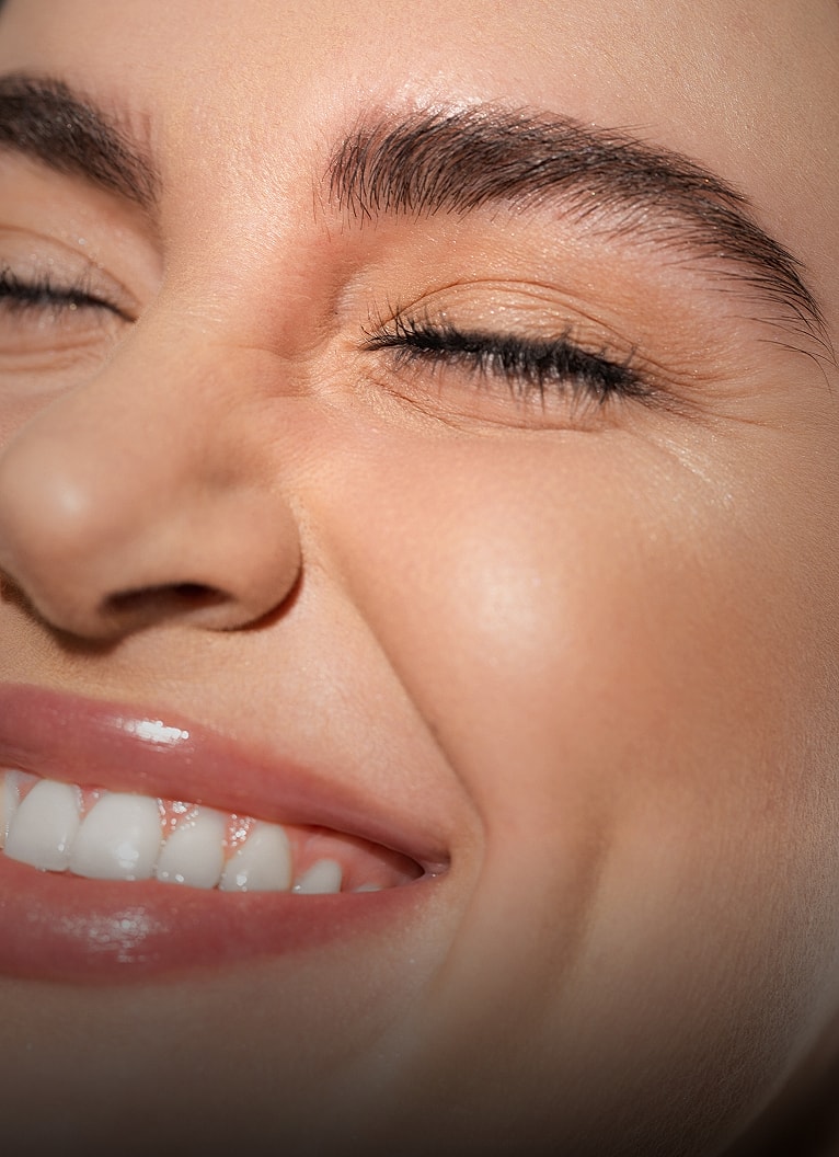 Smiling woman with closed eyes and radiant skin