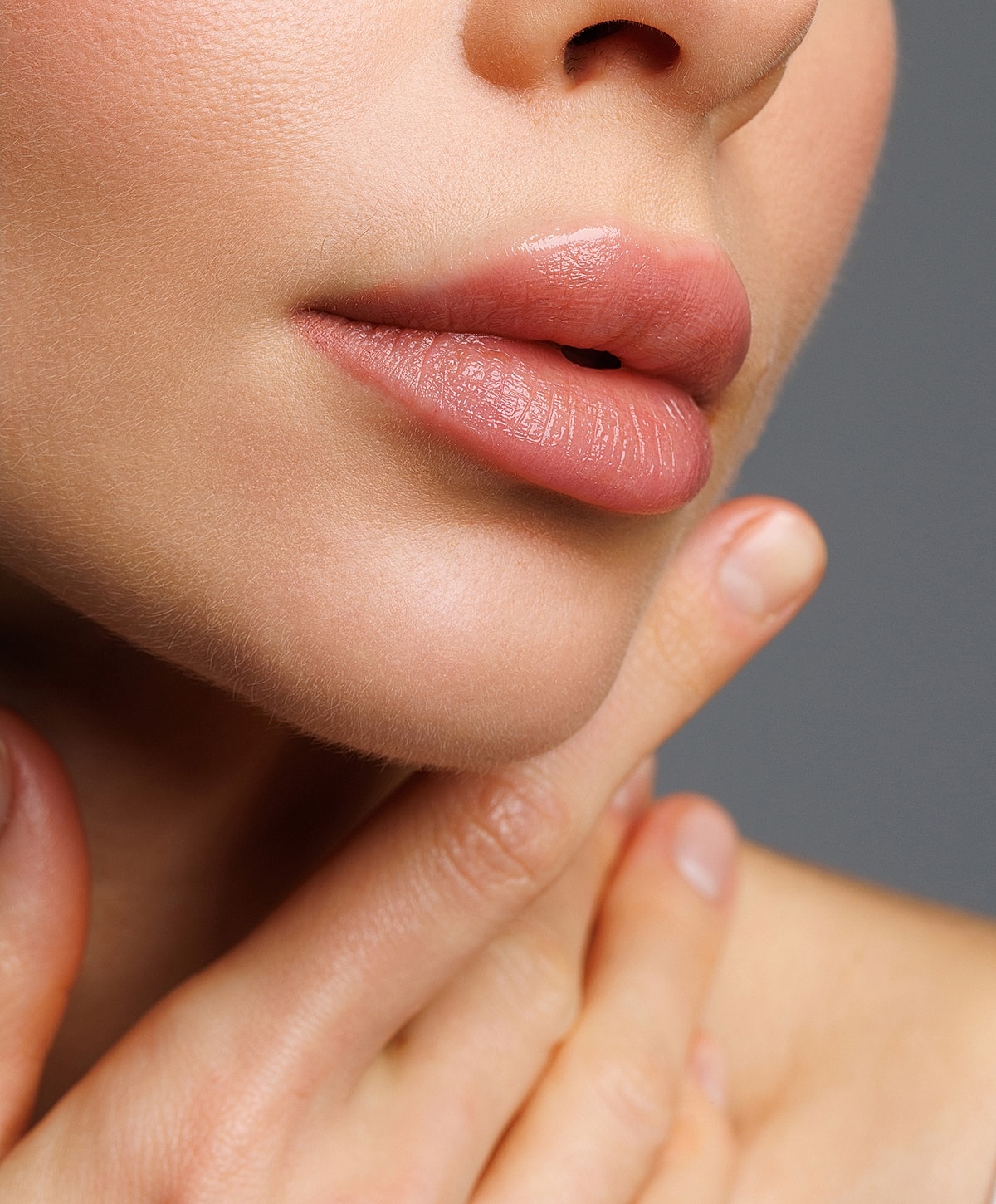 Close-up of lips and chin with gentle touch.