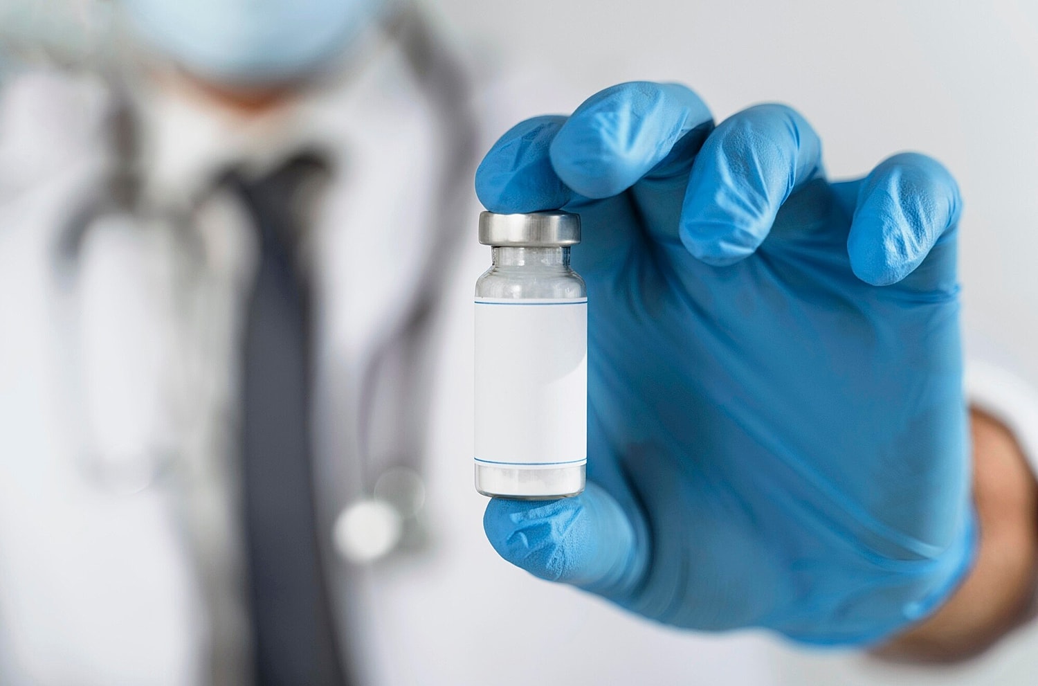 Healthcare professional holding a vaccine vial.
