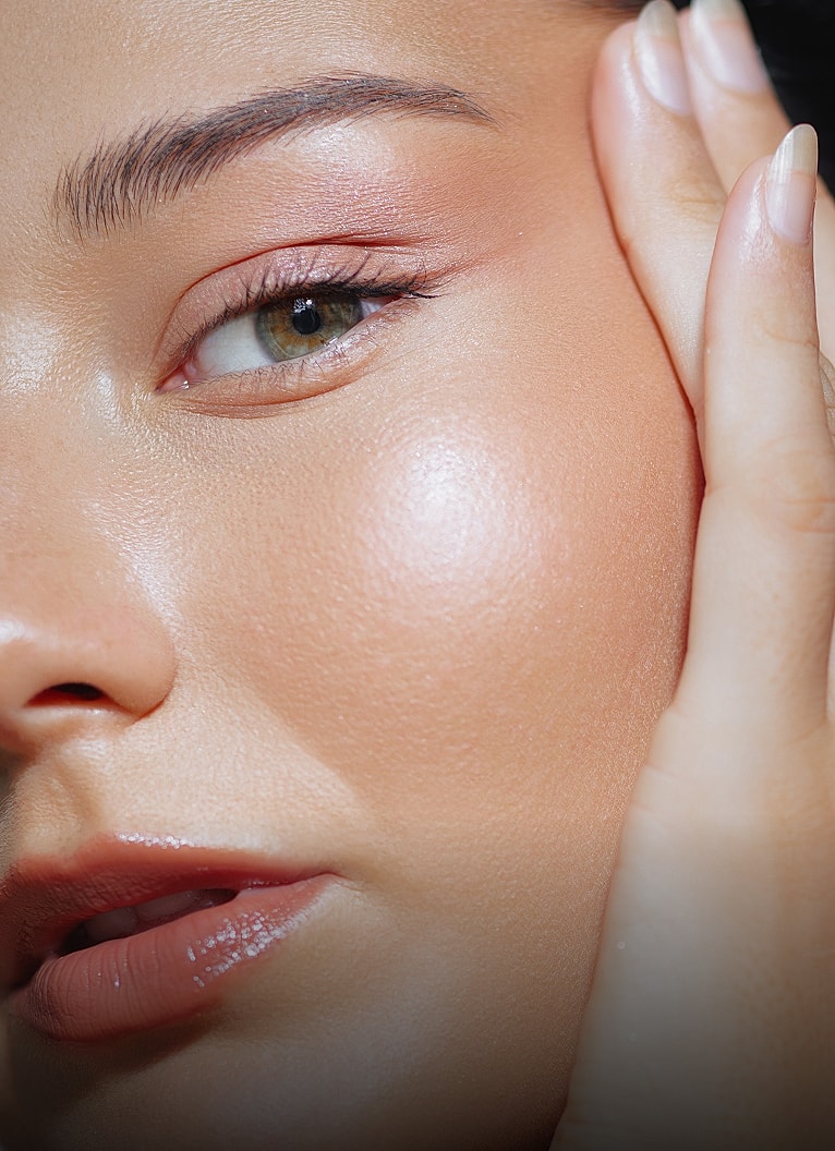 Close-up of a woman’s face with glowing skin.