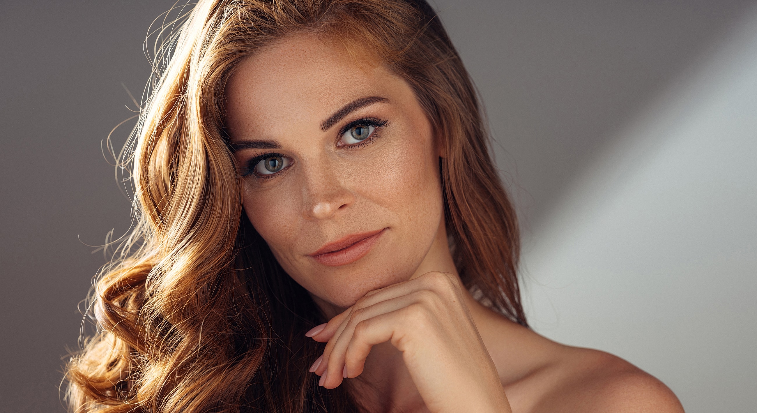 Portrait of a woman with wavy red hair.
