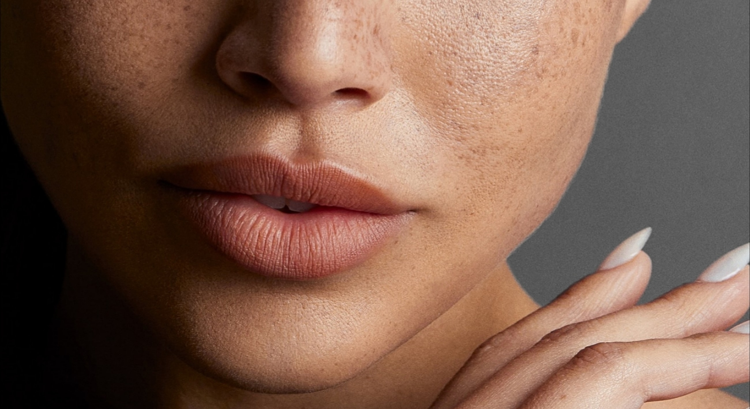 Close-up of lips and hand with textured skin.