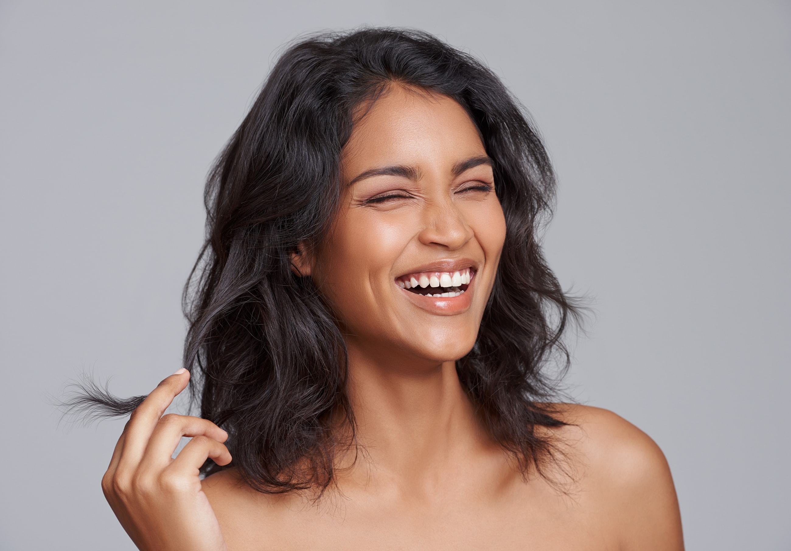 Smiling woman with dark, wavy hair.