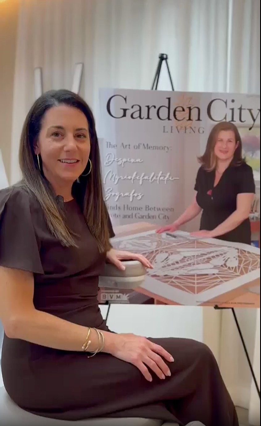 Woman seated by Garden City Living magazine display.