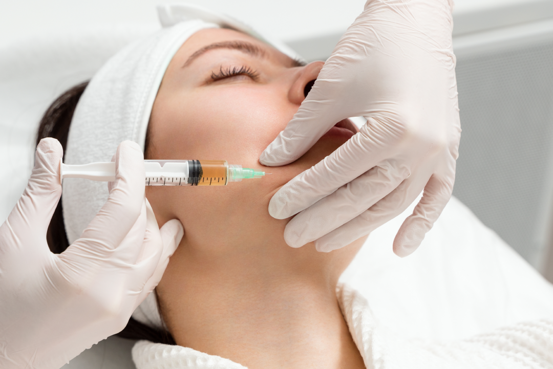 A skincare professional administering Jeuveau injections to a patient’s face during a clinical anti-aging treatment session.