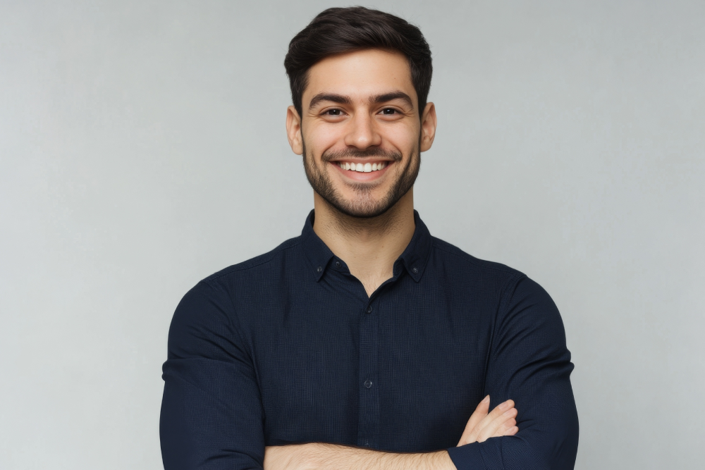 Smiling man in dark shirt representing cosmetic dermatology results.