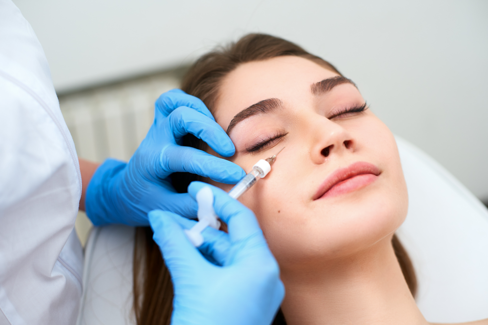Woman receiving under-eye dermal fillers at a clinic.