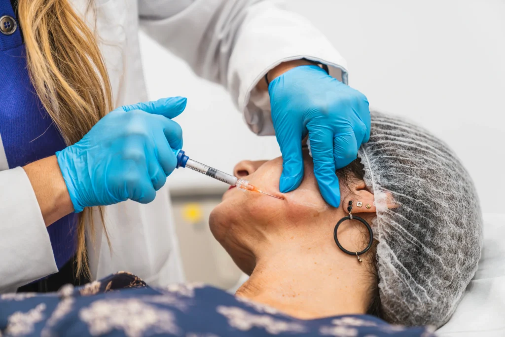 Practitioner administering an injectable treatment along a patient’s cheek during a cosmetic procedure